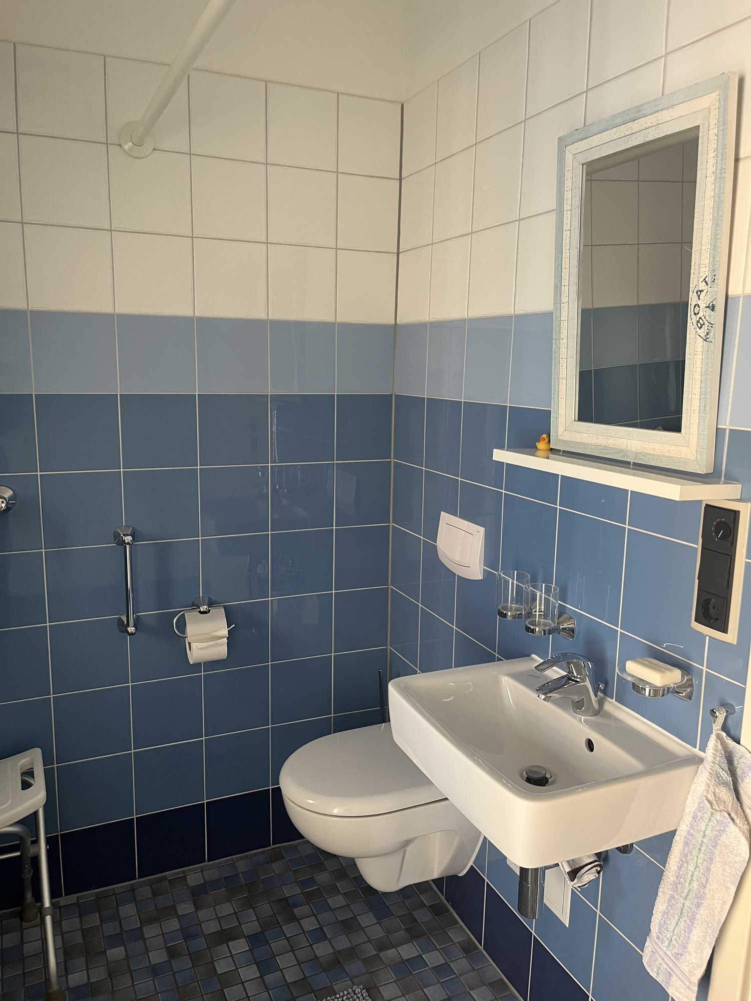 Badezimmer mit Waschbecken, WC und blauen Fliesen